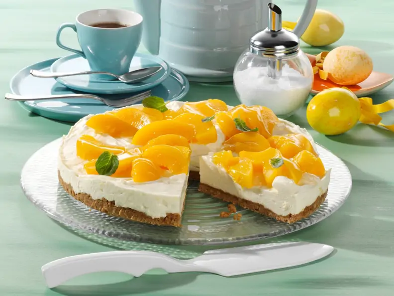 Weiße Schoko-Frischkäse-Torte mit Pfirsichen auf Krümelboden