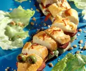 Baguette-Sanddwich als Schlange garniert