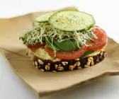 Brot mit Kichererbsenaufstich, Gemüse und Sprossen