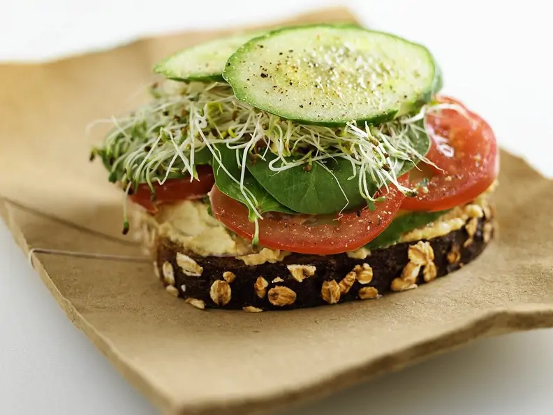 Brot mit Kichererbsenaufstich, Gemüse und Sprossen