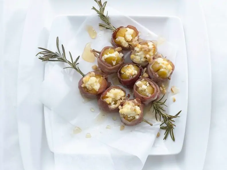 Umwickelte Feigen mit Ricotta-Nuss-Füllung auf einem Rosmarinspieß