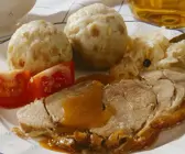 Klassischer Schweinebraten mit Klößen und Sauerkraut