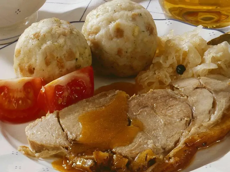 Klassischer Schweinebraten mit Klößen und Sauerkraut