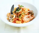 Paella mit Tintenfisch, Muscheln und Garnelen