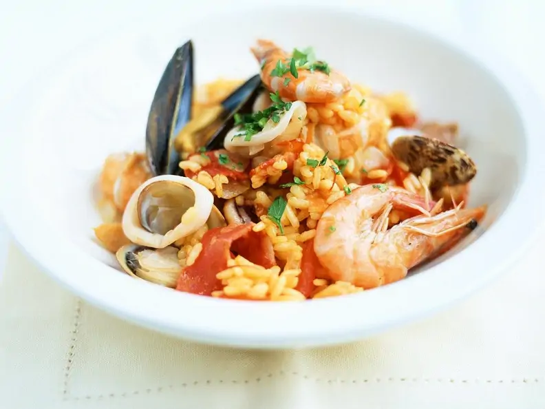 Paella mit Tintenfisch, Muscheln und Garnelen