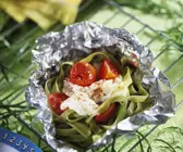 Grüne Nudeln mit Fisch und Tomaten