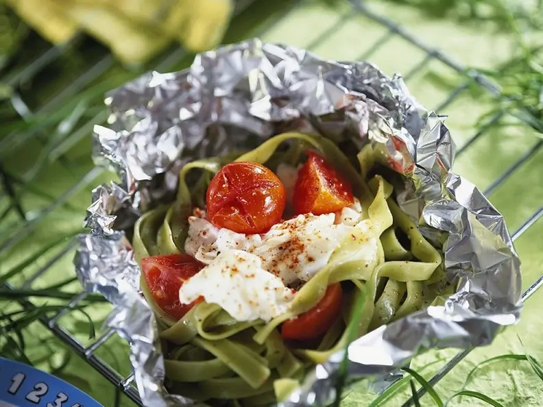 Grüne Nudeln mit Fisch und Tomaten