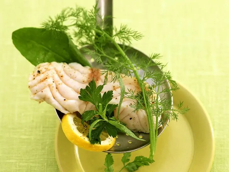 Gedämpftes Fischfilet auf Sieblöffel mit Kräutern