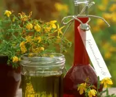 Flasche und Glas mit Johanniskrautöl (Heilöl)