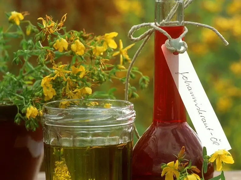 Flasche und Glas mit Johanniskrautöl (Heilöl)
