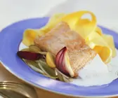 Bandnudeln mit Lachsfilet und Riesling-Trauben-Sauce und roten Zwiebeln