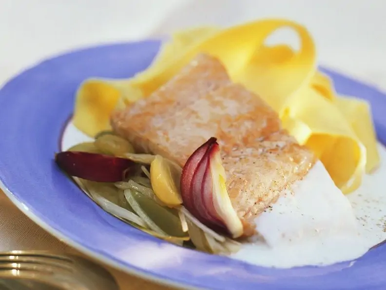 Bandnudeln mit Lachsfilet und Riesling-Trauben-Sauce und roten Zwiebeln