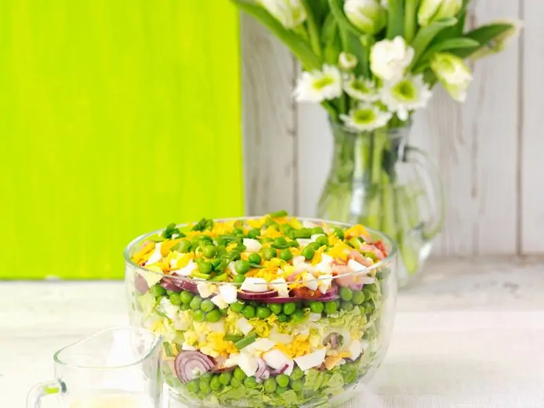 Schichtsalat mit Zwiebeln, Ei, Speck, Erbsen und Käse