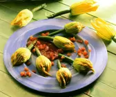 Käsecreme in der Zucchiniblüte mit Tomatensauce