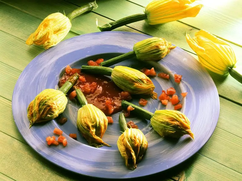 Käsecreme in der Zucchiniblüte mit Tomatensauce