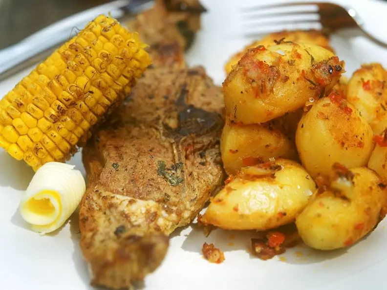 Lammkotelett mit Bratkartoffeln und Maiskolben