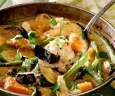 Bunte Gemüsesuppe in rustikaler Metallschale und auf Löffel