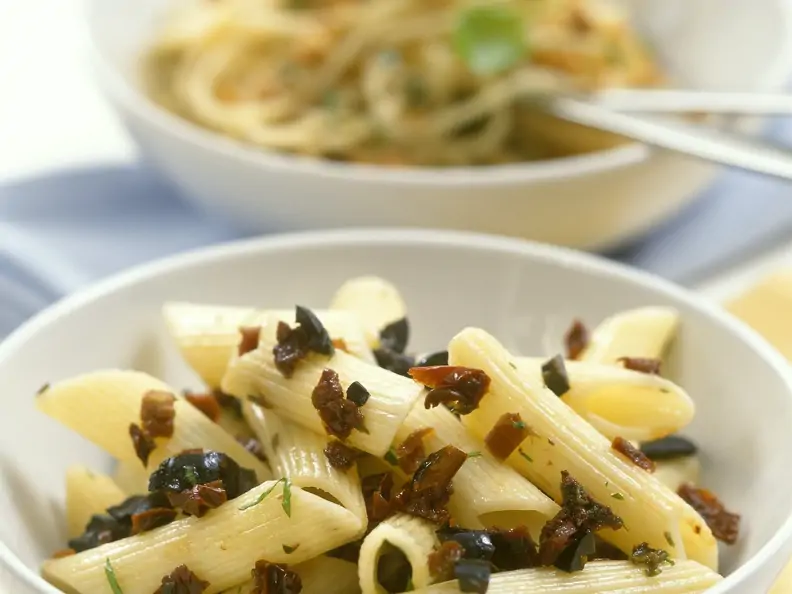Penne mit Sauce aus getrockneten Tomaten und schwarzen Oliven