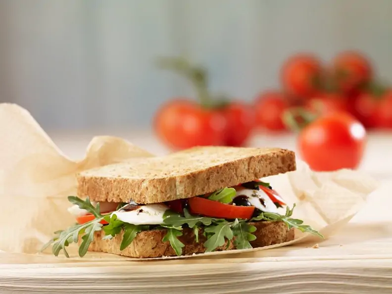 Sandwich aus Vollkorntoast mit Mozzarella, Tomate und Rucola