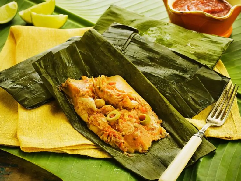Tamale mit Hähnchen und Oliven im Bananenblatt